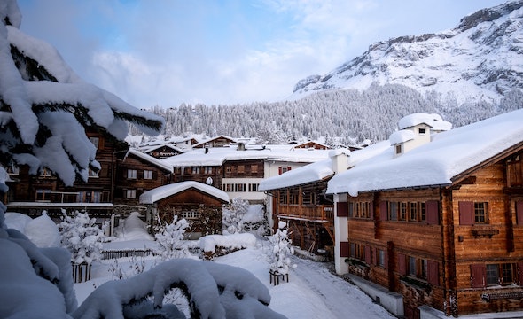 wooden cabin lodges covered in snow located along the Swiss Alps